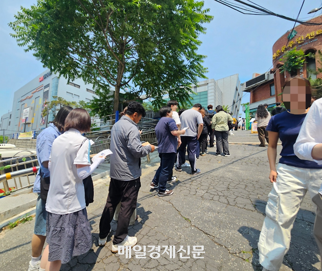 29일 오전 11시 30분께 구신촌동주민센터 사전투표소에서 유권자들이 배부받은 투표용지와 봉투를 들고 투표소 밖에 수십미터 줄을 서 있다. [지혜진 기자]