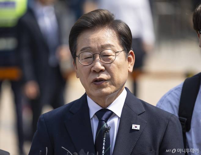 [서울=뉴시스] 조성우 기자 = 이재명 더불어민주당 대선후보가 제21대 대통령 선거 사전투표 첫날인 29일 오전 서울 서대문구 신촌동 주민센터 투표소에서 청년들과 함께 사전투표를 마치고 취재진의 질문에 답변하고 있다. (공동취재) 2025.05.29. photo@newsis.com /사진=
