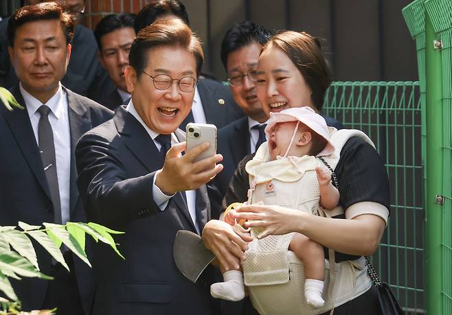 이재명(왼쪽) 더불어민주당 대선 후보가 제21대 대통령 선거 사전 투표 첫날인 29일 오전 서울 서대문구 신촌동 주민센터 투표소에서 한 시민과 함께 기념촬영을 하고 있다. 임세준 기자