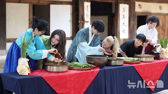 [서울=뉴시스] 김선웅 기자 = 단오(음력 5월 5일)를 이틀 앞둔 29일 서울 종로구 국립민속박물관 오촌댁 앞마당에서 열린 단오 세시행사에서 방문객들이 창포물 머리감기 체험을 하고 있다. 2025.05.29. mangusta@newsis.com