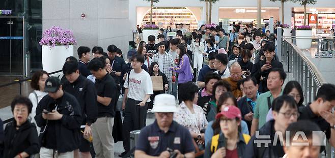 [인천공항=뉴시스] 김선웅 기자 = 제21대 대통령 선거 사전투표 첫날인 29일 인천국제공항 제1여객터미널 G체크인카운터 앞에 설치된 인천공항 사전투표소에서 여행을 앞둔 유권자들이 사전투표를 하기 위해 줄을 서고 있다. 2025.05.29. mangusta@newsis.com