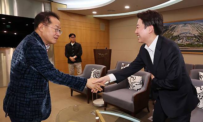 홍준표 전 대구시장이 지난 10일 오후 인천국제공항 제1여객터미널에서 미국 출국을 앞두고 배웅온 이준석 개혁신당 대선후보와 악수를 나누고 있다. 인천공항=뉴시스