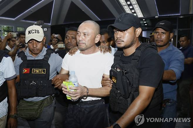 동티모르에서 추방되는 필리핀 전 하원의원 (딜리 AP=연합뉴스) 29일 여러 건의 살인 혐의로 기소된 아르놀포 테베스(가운데) 전 필리핀 하원의원이 동티모르 딜리 공항에서 경찰관들에 의해 이송되고 있다. 2025.5.29 photo@yna.co.kr