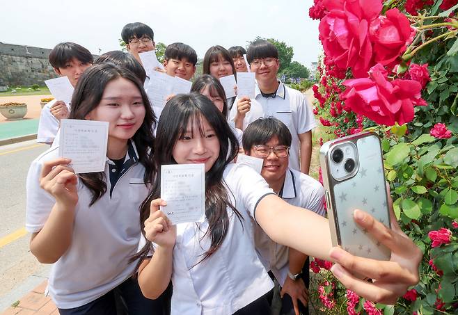 ▲ 제21대 대통령선거 사전투표일인 29일 오후 수원시 장안구 연무동행정복지센터 투표소에서 투표를 마친 삼일공업고등학교 3학년 학생들이 투표확인증을 들고 화홍문 장미화단에서 인증사진을 찍고 있다./전광현 기자 maggie@incheonilbo.com