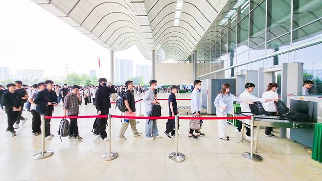 베트남 하노이 국립컨벤션센터에 삼성의 직무적성검사(GSAT)를 응시하는 응시자들이 시험장 입장 전 소지품 검사를 하는 모습. 신짜오 베트남 삼성 페이스북 갈무리