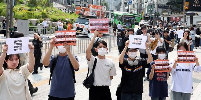 30일 오후 서울 동작구 중앙대학교 후문에서 대학생들이 유세를 펼치는 이준석 개혁신당 대선후보를 향해 혐오 발언 규탄 피켓을 들어 보이고 있다. 뉴시스