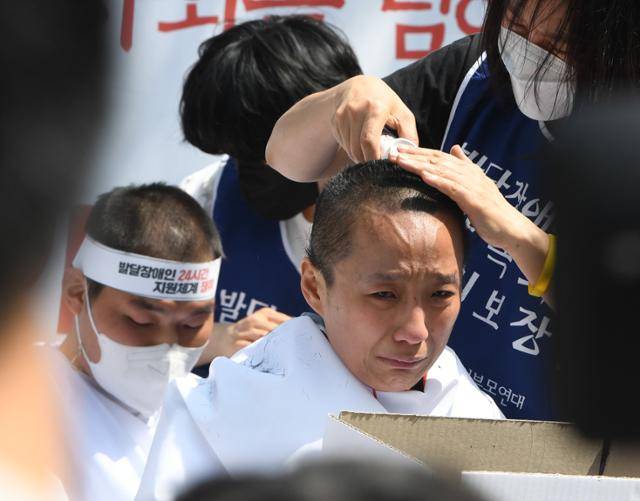 2022년 4월 서울 청와대 인근에서 '발달장애인 24시간 지원 체계 구축을 위한 1박 2일 집중 결의대회'에 참가한 발달장애인 부모들이 삭발을 하며 눈물을 흘리고 있다. 배우한 기자