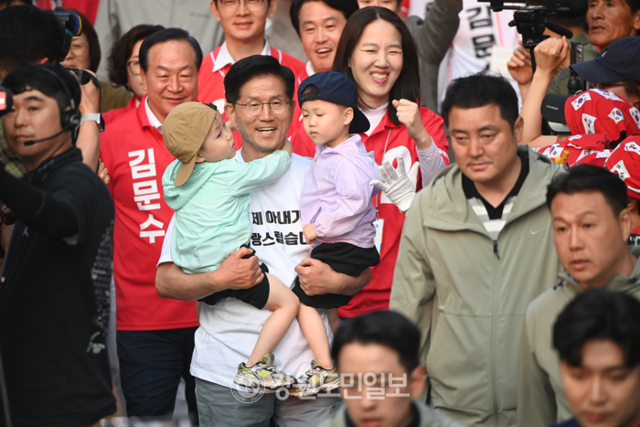 ▲ 국민의힘 김문수 대선 후보가 30일 춘천 시청 앞에서 열린 유세에 쌍둥이 형제를 안고 입장하고 있다. 방도겸 기자