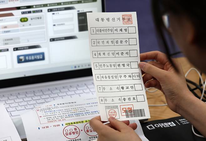 제21대 대통령선거 사전투표를 하루 앞둔 28일 광주 동구 지원2동 행정복지센터에 마련된 사전투표소에서 선관위 관계자가 모의시험하고 있다. [연합]