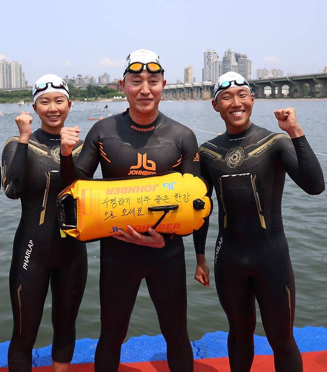 오세훈 서울시장이 30일 ‘쉬엄쉬엄 한강 3종 축제’ 1일차 수영종목에 출발 전 ‘수영하기 너무 좋은 한강으로 오세요 수질 환상적!’ 안전부이를 들고 도강을 준비하고 있다.. [서울시 제공]