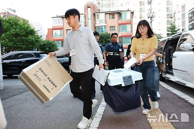 [서울=뉴시스] 황준선 기자 = 제21대 대통령선거 사전투표 첫날인 지난 29일 오후 투표가 종료되자 선거관리위원회 관계자들이 서울 동대문구·성동구 합동청사로 투표함을 이송하고 있다. 2025.05.29. hwang@newsis.com