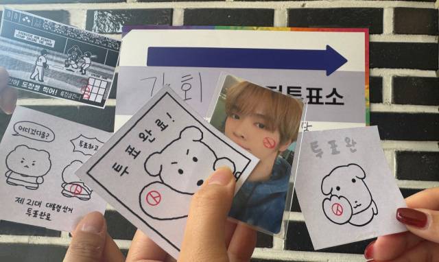 인기 캐릭터와 아이돌 포토카드를 활용한 투표 인증샷. 강지원 기자