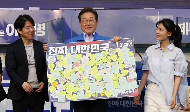 이재명 더불어민주당 대선후보가 5월21일 인천광역시 계양구 계양역 앞 광장에서 시민들이 붙인 소망 쪽지 액자를 받고 있다. ⓒ공동취재