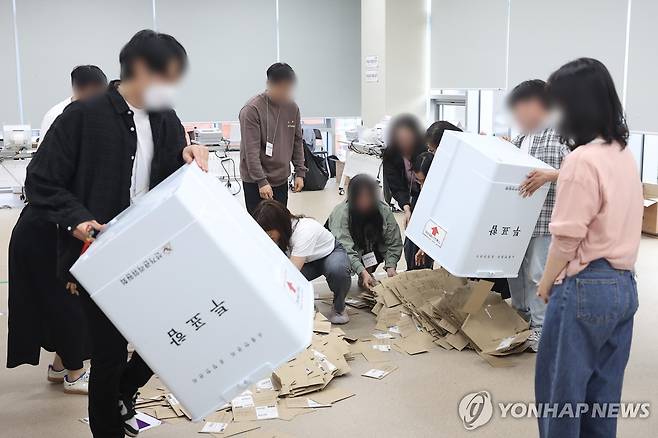 제21대 대선 사전투표 '끝' (서울=연합뉴스) 김도훈 기자 = 제21대 대통령선거 사전투표 둘째 날인 30일 서울 중구 을지누리센터에 마련된 사전투표소에서 사전투표사무원들이 참관인 및 공정선거참관단이 지켜보는 가운데 관외투표함을 열고 있다. 2025.5.30 superdoo82@yna.co.kr