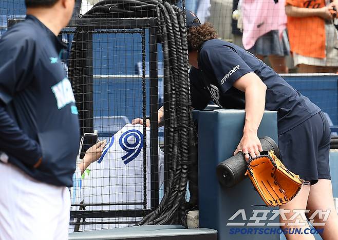 긴 팔을 뻗어 유니폼을 받는 폰세