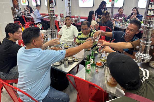 필리핀 마닐라 말라떼에 있는 식당 '삼겹살라맛(Samgyupsalamat)'에서 고객들이 하이트진로 소주를 마시고 있다. 하이트진로 제공