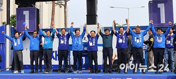 이재명(왼쪽 다섯번째) 더불어민주당 대선후보가 31일 청주오창프라자 앞 광장에서 연 유세에서 충북권 민주당 전·현직 의원들과 함께 만세를 하며 지지를 호소하고 있다. [사진=윤재원 기자]