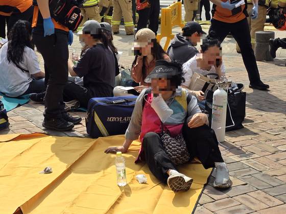 31일 오전 서울 지하철 5호선 여의나루~마포역에서 발생한 방화로 다친 승객들이 마포역 2번 출구 앞에서 소방으로부터 응급처치를 받고 있다. 이영근 기자