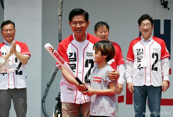 [속초=뉴시스] 김문수 국민의힘 대선 후보가 31일 강원 속초 관광수산시장에서 유세를 하기 전 선물받은 야구 배트를 들고 포즈를 취하고 있다. 2025.05.31.