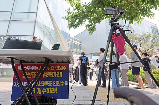 제21대 대통령선거 사전투표 둘째 날인 30일 서울 강남구 역삼1동주민센터에 마련된 사전투표소 앞에서 유권자들의 수를 동영상으로 기록하는 ‘3500 사전선거 투표소 국민감시집회’가 열리고 있다. [연합]
