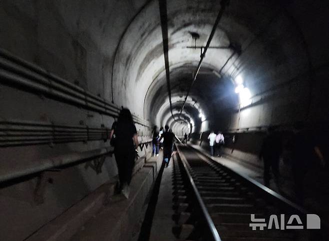 [서울=뉴시스] 조수정 기자 = 31일 오전 8시 47분께 서울 지하철 5호선 여의나루에서 마포역 방향으로 향하던 지하철에서 방화로 인한 화재가 발생해 승객들이 철로를 통해 대피하고 있다. (사진=독자 제공) 2025.05.31. photo@newsis.com