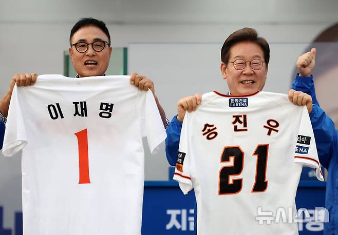 [대전=뉴시스] 조성우 기자 = 이재명 더불어민주당 대선후보가 31일 오후 대전 서구 대전시청 앞 보라매공원에서 열린 유세에서 송진우 전 한화이글수 투수가 전달한 유니폼을 들어 보이고 있다. 2025.05.31. xconfind@newsis.com