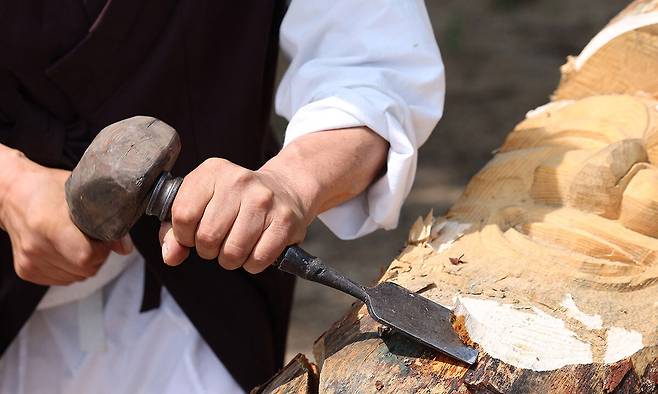 장승을 조각하고 있는 김 명인