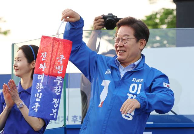 이재명 더불어민주당 대선 후보가 30일 충북 충주시 충주체육관 시계탑광장에서 열린 유세에서 "진짜 대한민국"이라고 쓰인 청사초롱을 들어보이고 있다. 연합뉴스