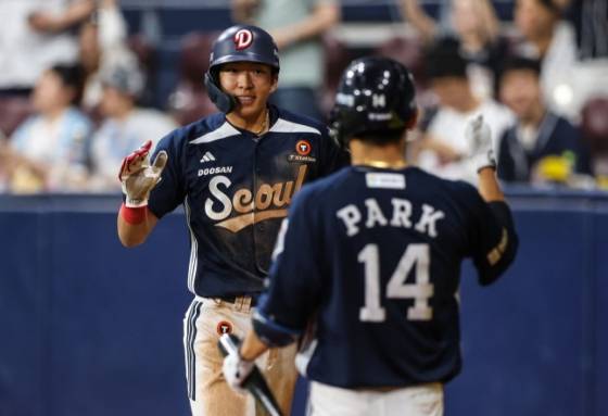 김민석(왼쪽)이 득점한 뒤 박계범의 환영을 받고 있다. /사진=두산 베어스 제공