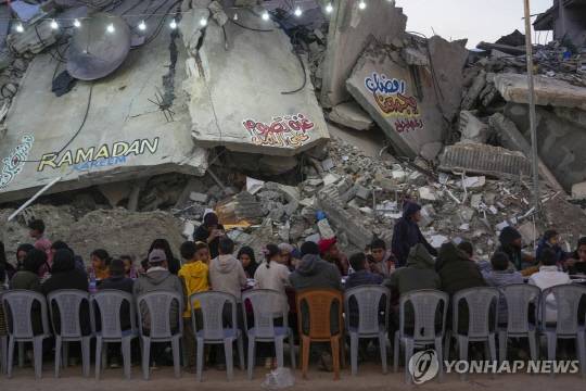 라마단 첫날 폐허 주변에 모여앉은 가자지구 라파 주민들 [AP 연합뉴스 자료사진]