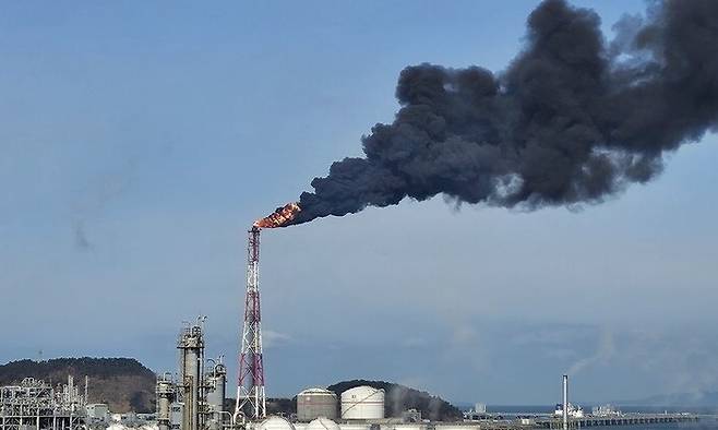 25일 오전 충남 서산 대산석유화학단지 내 LG화학과 롯데케미칼에 전기 공급이 끊기면서 공장 가동이 멈춘 가운데 생산공정에 투입된 원료를 태우는 작업이 진행되면서 굴뚝에서 검은 연기가 뿜어져 나오고 있다. 연합뉴스