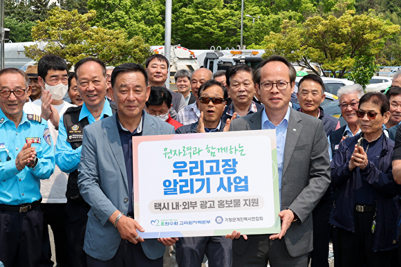 남영규 한국수력원자력 고리원자력본부 대외협력처장(오른쪽)과 강철진 부산 기장군개인택시연합회 회장(왼쪽)이 행사 관계자들과 함께 기념촬영을 하고 있다. [사진=한국수력원자력 고리원자력본부]