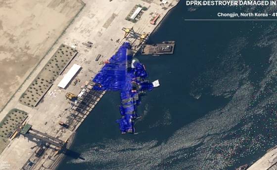 청진에서 벌어진 진수식 도중 사고로 좌초된 최현급 구축함 2번함을 위장막으로 감싼 모습. 김정은은 6월 말까지 원상 복구하라고 명령했지만, 쉽지 않을 전망이다. 영국 싱크탱크 오픈소스센터