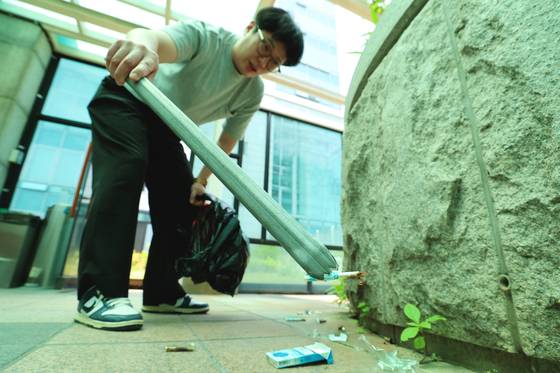 서울 성동구청 직원이 청사 주변에 버려져 있는 담배꽁초를 치우고 있다. 사진 서울 성동구