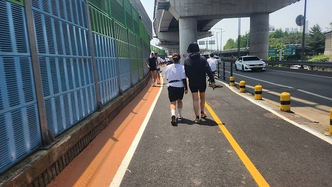 좁은 도로에 달리기 선수들이 자전거 도로로 가고 있다. 안병준 기자