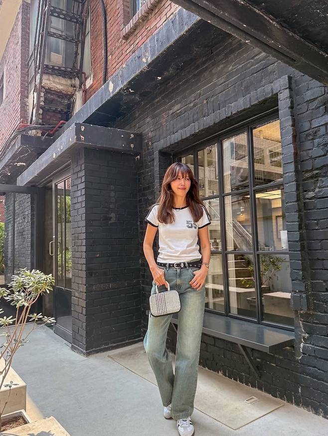 화이트 배색 반팔 티셔츠에 강한 워싱이 들어간 와이드 데님 팬츠를 매치했다.사진=채정안 SNS