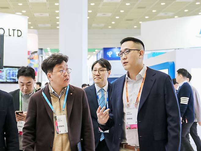 김동선(오른쪽) 한화세미텍 미래비전총괄 부사장이 올 2월 ‘세미콘코리아 2025’ 현장을 찾아 부스를 돌며 기술현황에 대한 설명을 듣고 있는 모습. [한화세미텍 제공]