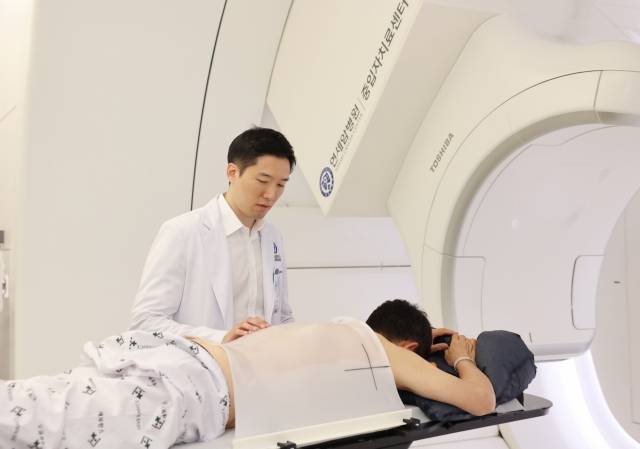 김경환(왼쪽) 세브란스병원 방사선종양학과 교수가 중입자 치료 시작 전 환자를 살피고 있다. 사진 제공=연세암병원