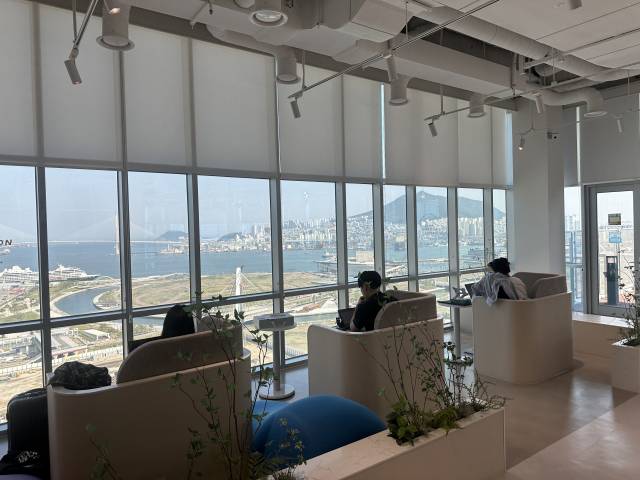 부산 워케이션 거점센터에서 일하는 참가자들. 창문 너머로 북항 전경이 보인다. 부산창조경제혁신센터 제공