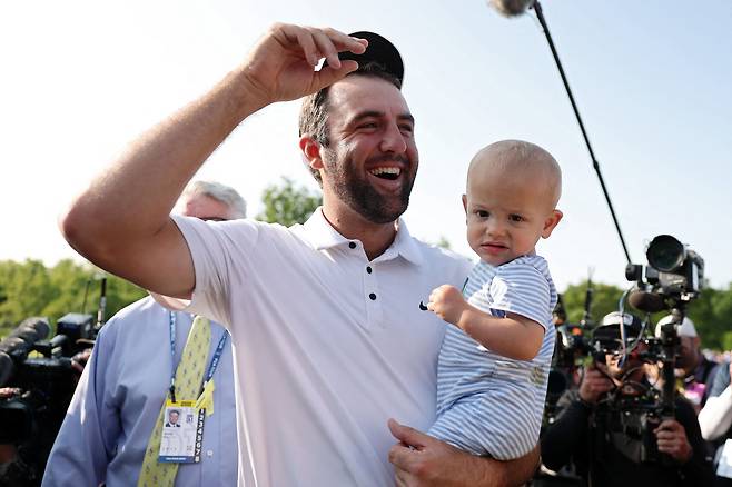 PGA투어 메모리얼 토너먼트 2연패를 차지한 스코티 셰플러가 아들 베넷을 안고 팬들의 축하에 답하고 있다. /AFP 연합뉴스