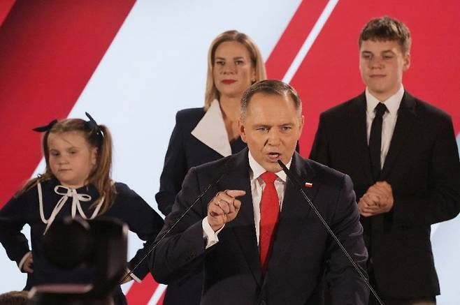 1일 폴란드 대선 결선투표에서 이긴 카롤 나브로츠키 후보(앞줄)가 승리를 확정한 후 수도 바르샤바에서 지지층에게 연설하고 있다. 강경보수 성향인 그는 난민협정 탈퇴, 도널드 트럼프 미국 대통령과의 협력 강화 등을 예고했다. 바르샤바=AP 뉴시스