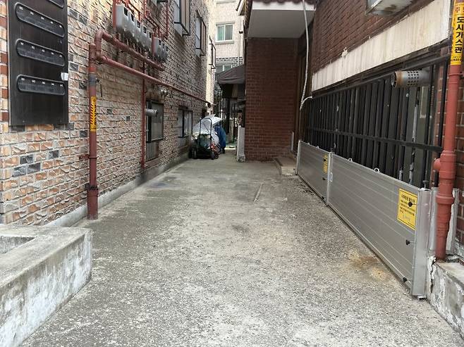 서울 동작구 상도역 2번 출구 인근 반지하 골목에서 물막이판이 설치된 건물(오른쪽)과 물막이판 없이 방범창만 설치된 건물(왼쪽)의 모습. 사진=이현정 기자