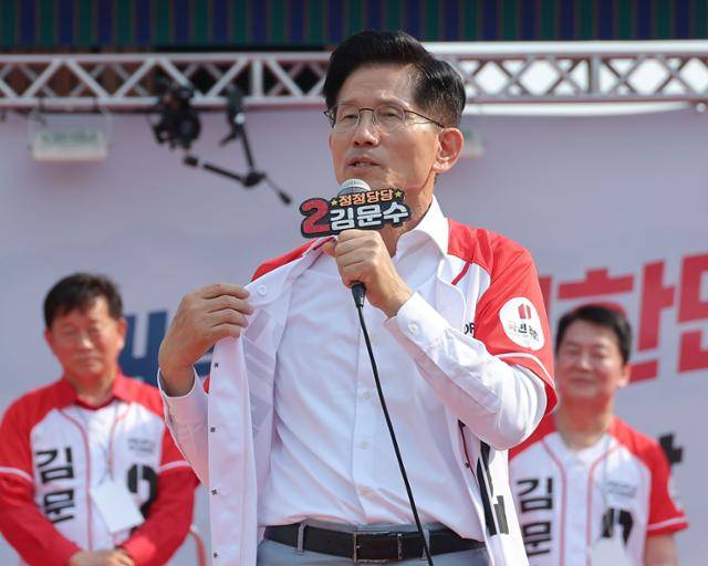 김문수 국민의힘 대선 후보가 지난달 29일 경기 안산시 안산문화광장에서 열린 유세에서 방탄복을 착용하는 이재명 민주당 후보를 비판하며 자신의 겉옷을 벗어 보이고 있다. 연합뉴스