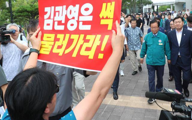 김관영(오른쪽) 전북지사가 지난해 7월 26일 전북 완주군 완주군청에서 열릴 예정이었던 '도민과의 대화'를 위해 유희태 완주군수의 안내를 받으며 이동하고 있다. 전주-완주 통합에 반대한 군민들이 김 지사를 향해 피켓을 들고 항의하고 있다. 뉴스1