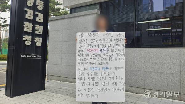용인 성복동 사전투표소 참관인이 2일 오전 수원지검 앞에서 선관위 대응을 지적하는 호소문을 들고 1인 시위를 벌이고 있다. 송상호기자