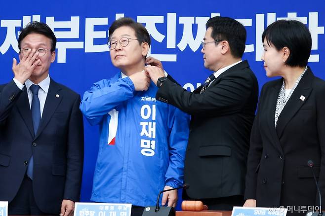 (서울=뉴스1) 안은나 기자 = 박찬대 더불어민주당 대표 직무대행 겸 원내대표가 28일 서울 여의도 국회에서 열린 최고위원회의에서 이재명 대선 후보에게 선거복을 입혀준 뒤 옷깃을 정리하고 있다. 2025.4.28/뉴스1  Copyright (C) 뉴스1. All rights reserved. 무단 전재 및 재배포,  AI학습 이용 금지. /사진=(서울=뉴스1) 안은나 기자