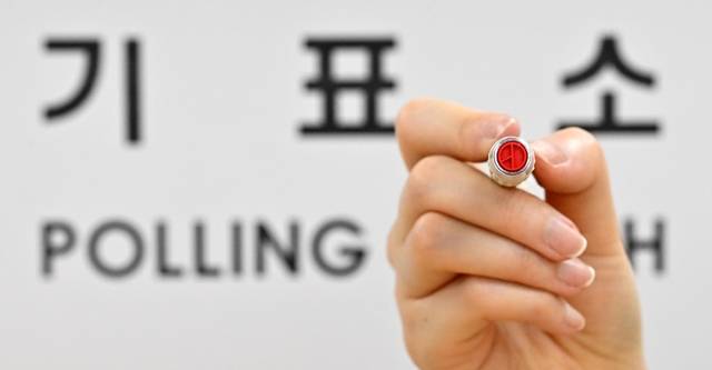 제21대 대선를 하루 앞둔 2일 서울 용산구 청파도서관에 마련된 청파동 제1투표소에서 관계자가 기표 도장을 들어 보이고 있다.  [공동취재] 연합뉴스