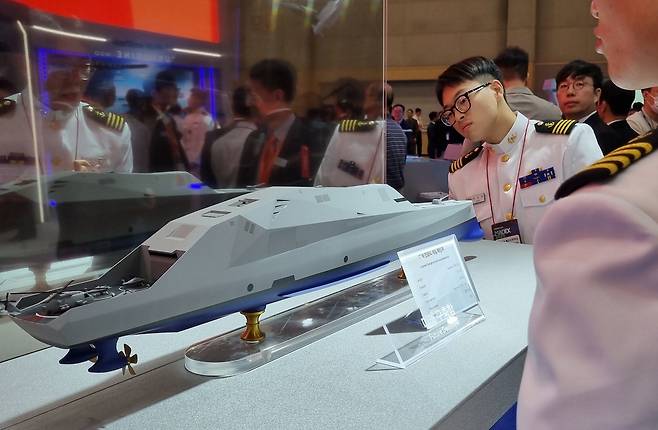 ‘국제해양방위산업전(MADEX) 2025’가 부산 벡스코(BEXCO)에서 28~31일 진행됐다.  해군 장병들이 한화오션의 미래구축함 목업을 살펴보고 있다. [신대원 기자]