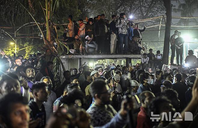 [다카=AP/뉴시스]  2월 6일(현지 시간) 방글라데시 다카 단몬디 지역에서 시위대가 중장비로 셰이크 하시나 전 총리의 부친이자 '건국의 아버지'인 무지부르 라만의 저택을 철거하는 모습을 지켜보고 있다. 인도에 망명 중인 하시나 전 총리가 자신이 이끌던 정당 아와미연맹(AL)을 앞세워 정치적 재기를 노리는 행보를 보이자, 그에 반대하는 시위대는 방글라데시 독립의 상징이었던 라만의 저택을 훼손하고 철거하기에 이르렀다. 2025.06.02.