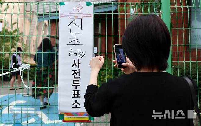 [서울=뉴시스] 이영환 기자 = 한 유권자가 제21대 대통령 선거 사전투표 이틀째인 30일 오전 서울 서대문구 구 신촌동주민센터에 마련된 사전투표소에서 투표를 마친 후 인증샷을 촬영하고 있다. 2025.05.30.  20hwan@newsis.com